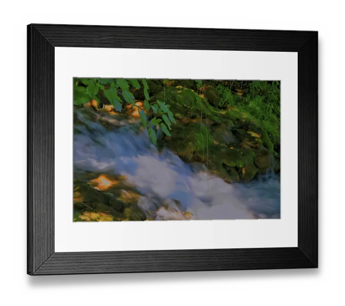 Framed Print : A small stream flows quietly over moss-covered stones Framed Print : A small stream flows quietly over moss-covered stones