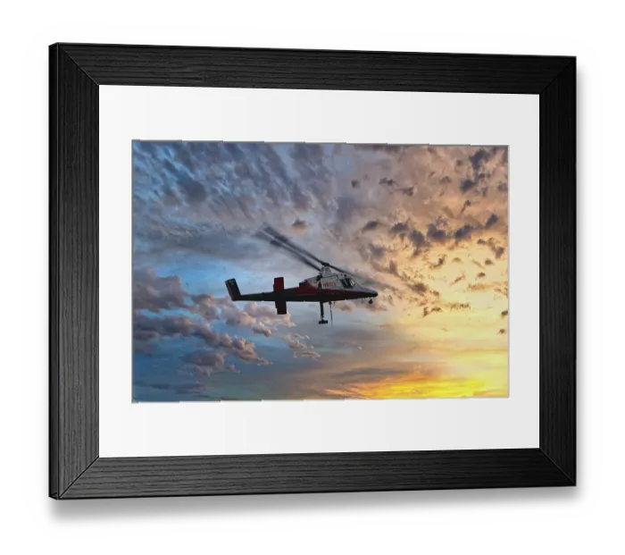 Framed Print : A helicopter flies in front of a colourful sunset with dramatic cloud formations
