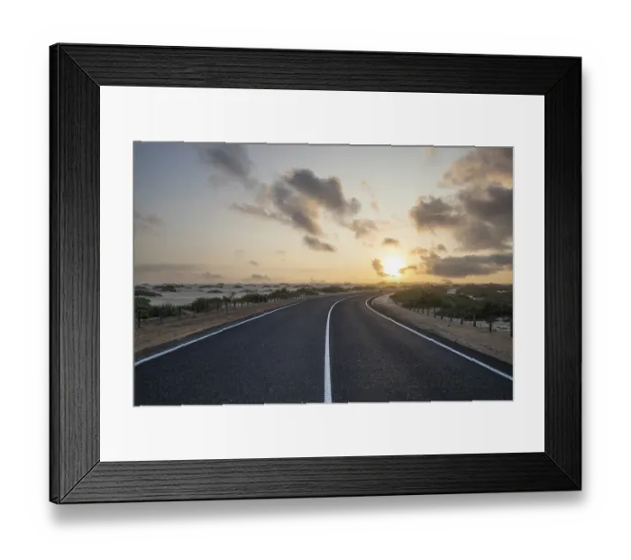Framed Print : Road through a dune. Sunrise in the morning on a road with clouds in the sky Framed Print : Road through a dune. Sunrise in the morning on a road with clouds in the sky