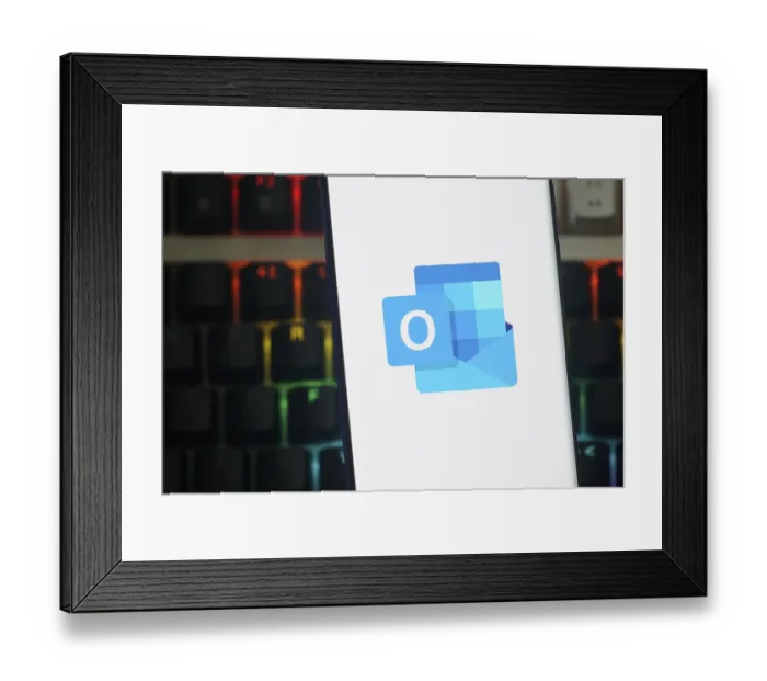 Framed Print : Outlook logo displayed on a smartphone screen against a keyboard backdrop Framed Print : Outlook logo displayed on a smartphone screen against a keyboard backdrop