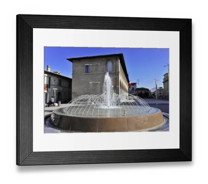 Framed Print : A central fountain bubbles in front of an Italian building in a sunny square