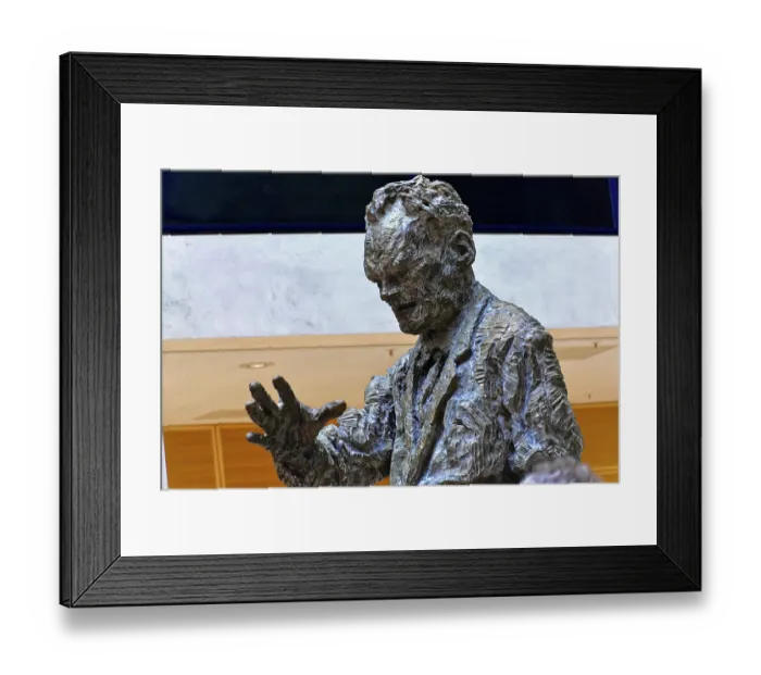 Framed Print : Bronze statue of a man in a modern lobby of a building