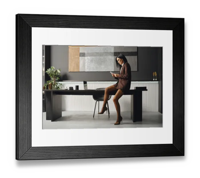 Framed Print : Serious business woman in a brown suit sits on a desk Framed Print : Serious business woman in a brown suit sits on a desk