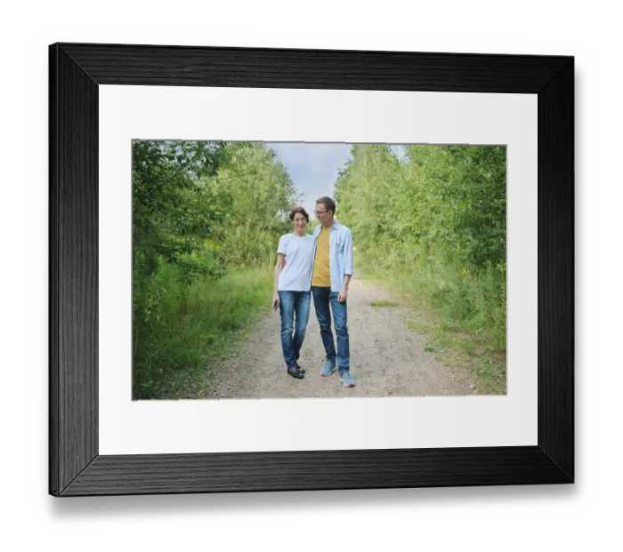 Framed Print : A middle-aged couple enjoys a stroll along a gravel path shaded by lush greenery Framed Print : A middle-aged couple enjoys a stroll along a gravel path shaded by lush greenery
