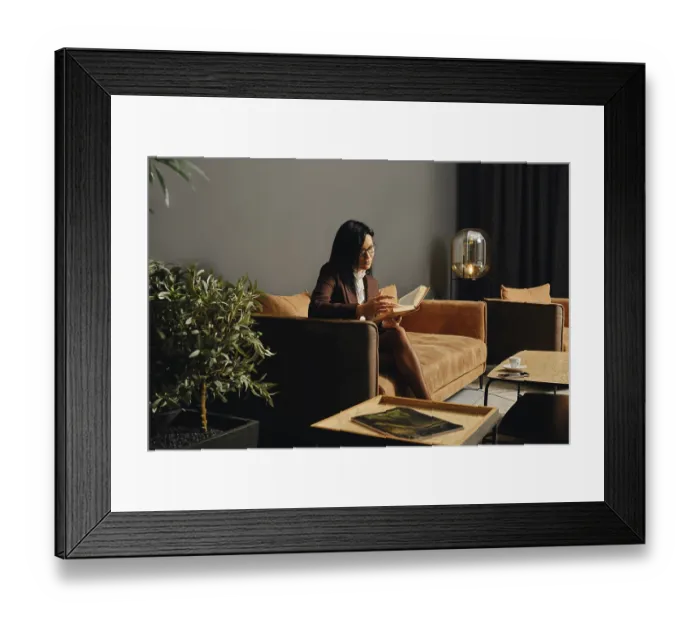 Framed Print : A woman sits comfortably on a modern couch