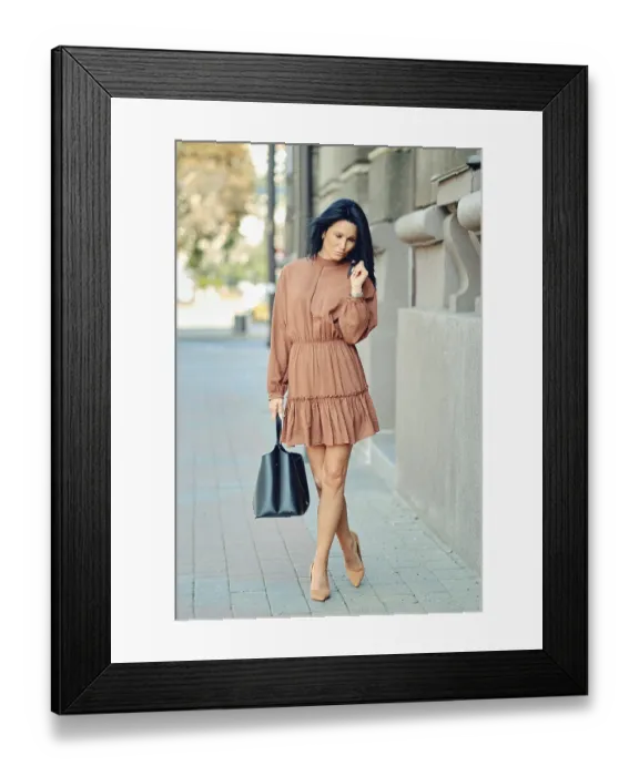 Framed Print : A woman strolls along a city sidewalk during daytime