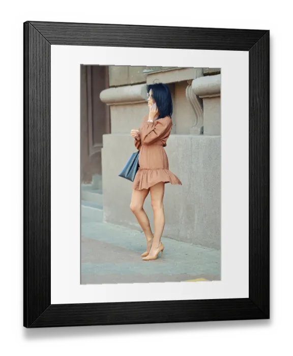 Framed Print : A woman is standing on a city sidewalk