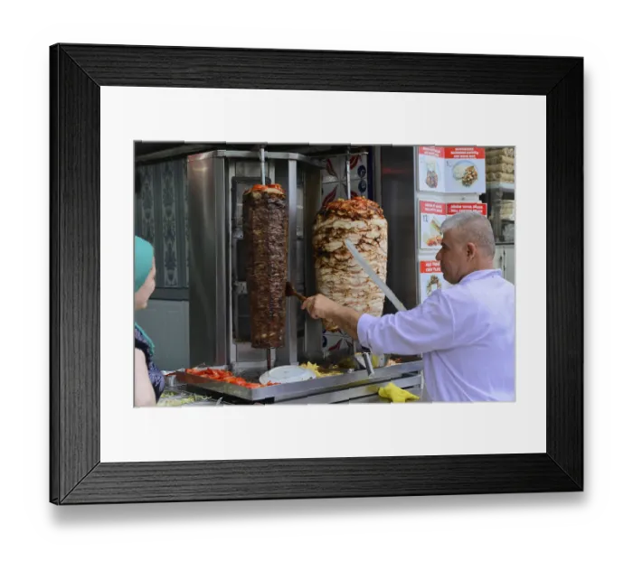 Framed Print : A cook prepares doner kebab at a street food stall