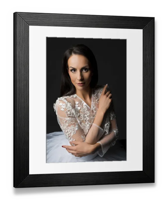 Framed Print : Charming tender young brunette bride in classy delicate white lace gown looking at camera against black background