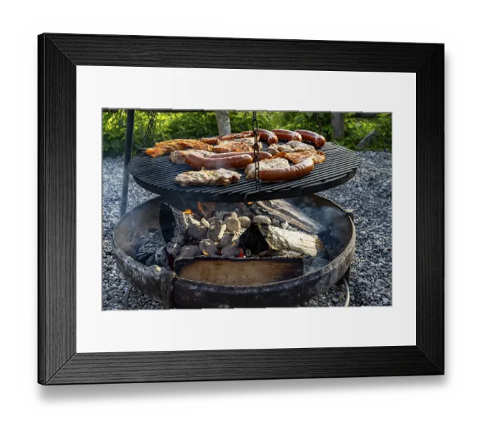 Framed Print : Meat and sausages on the grill over a fire bowl during a barbecue