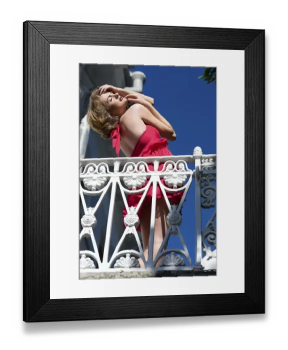 Framed Print : Beautiful woman in a red dress stands on the balcony