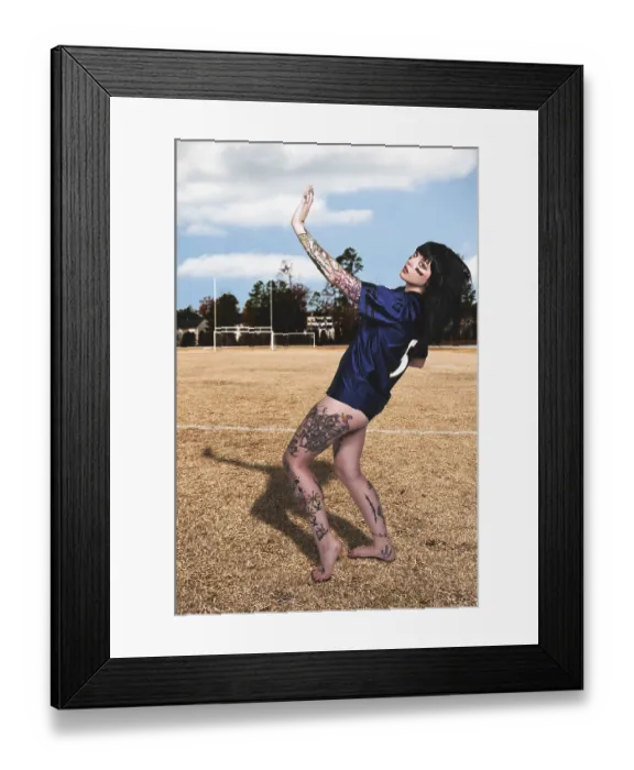 Framed Print : Beautiful young woman playing a game of football