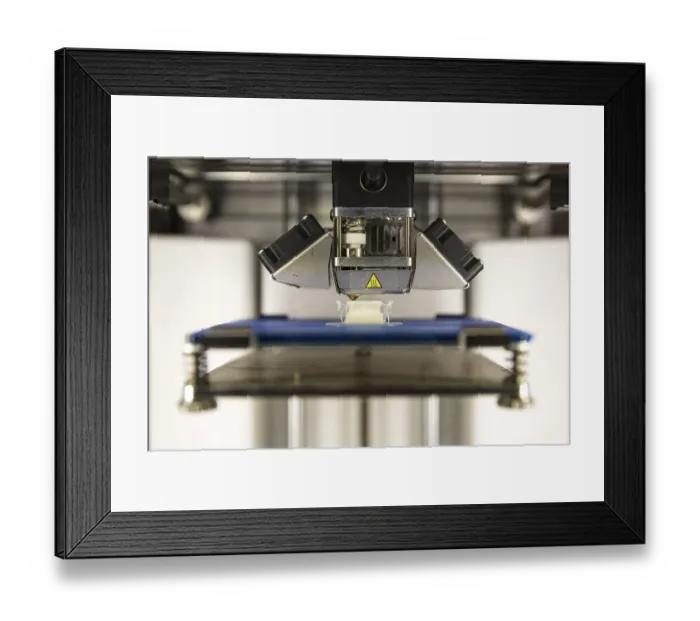 Framed Print : A 3D printer prints a white plastic detail
