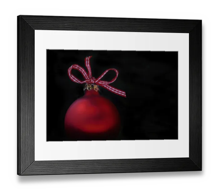 Framed Print : Red Christmas tree bauble with bow on a black background