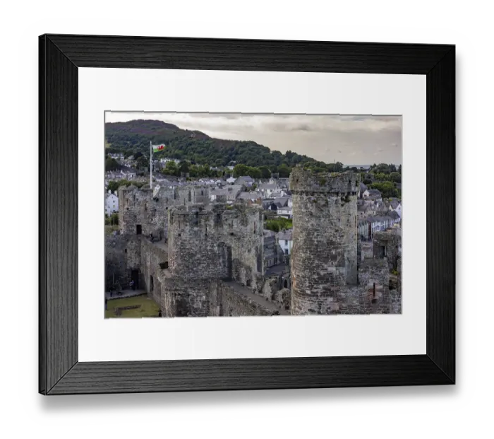 Framed Print : Conwy Castle, medieval castle with towers and surrounding town in a green landscape under a cloudy sky