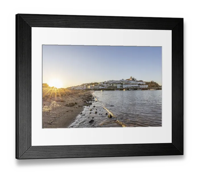 Framed Print : Sunrise on the Atlantic, skyline of a fishing village behind a harbour