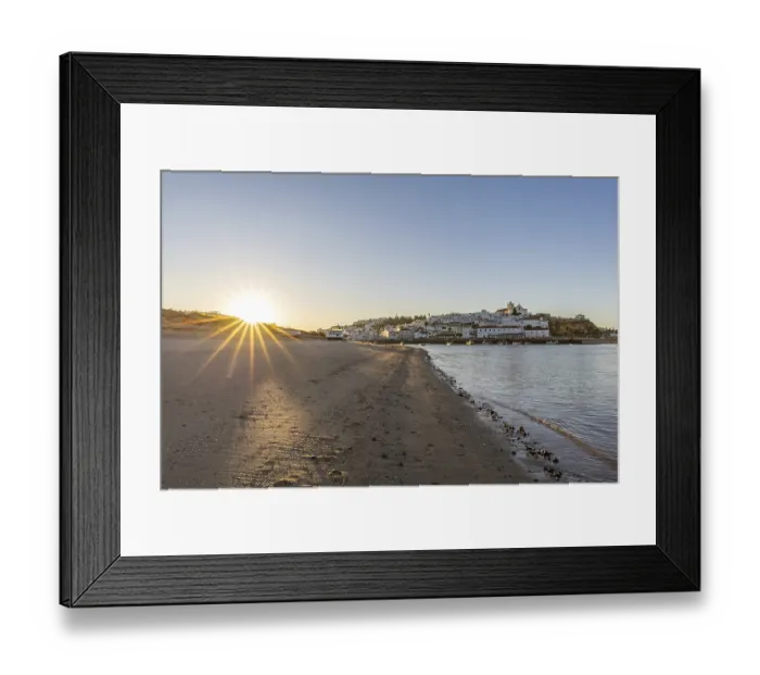 Framed Print : Sunrise on the Atlantic, skyline of a fishing village behind a harbour
