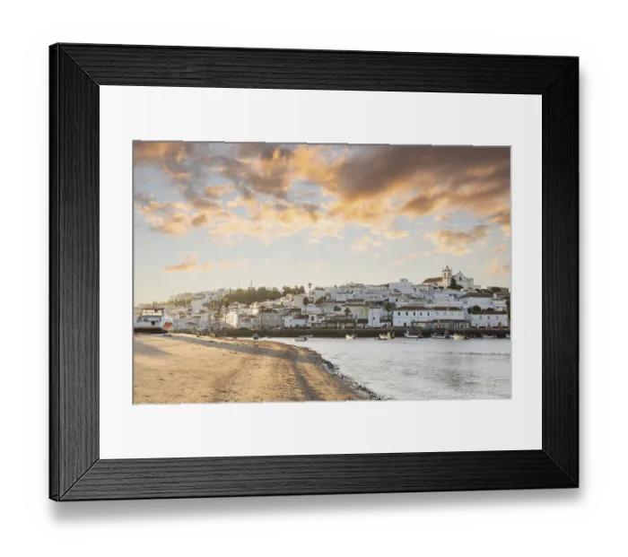 Framed Print : Sunrise on the Atlantic, skyline of a fishing village behind a harbour