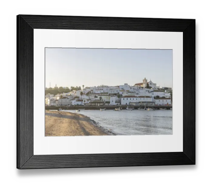 Framed Print : Sunrise on the Atlantic, skyline of a fishing village behind a harbour