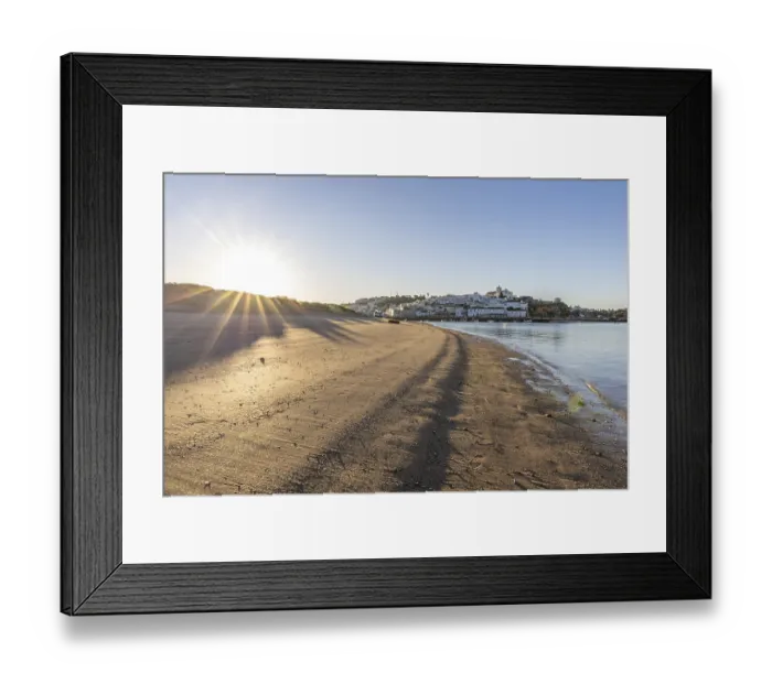 Framed Print : Sunrise on the Atlantic, skyline of a fishing village behind a harbour