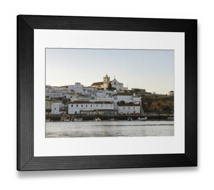 Framed Print : Sunrise on the Atlantic, skyline of a fishing village behind a harbour