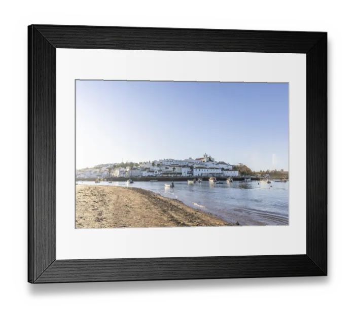 Framed Print : Sunrise on the Atlantic, skyline of a fishing village behind a harbour