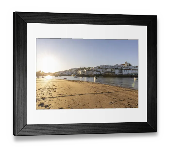 Framed Print : Sunrise on the Atlantic, skyline of a fishing village behind a harbour