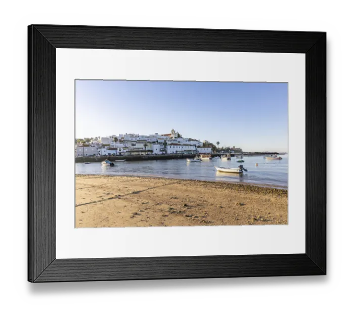 Framed Print : Sunrise on the Atlantic, skyline of a fishing village behind a harbour