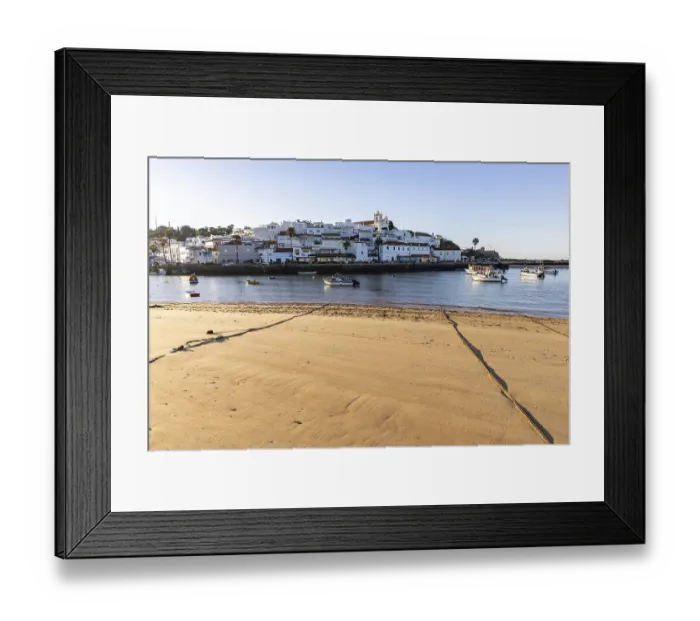Framed Print : Sunrise on the Atlantic, skyline of a fishing village behind a harbour