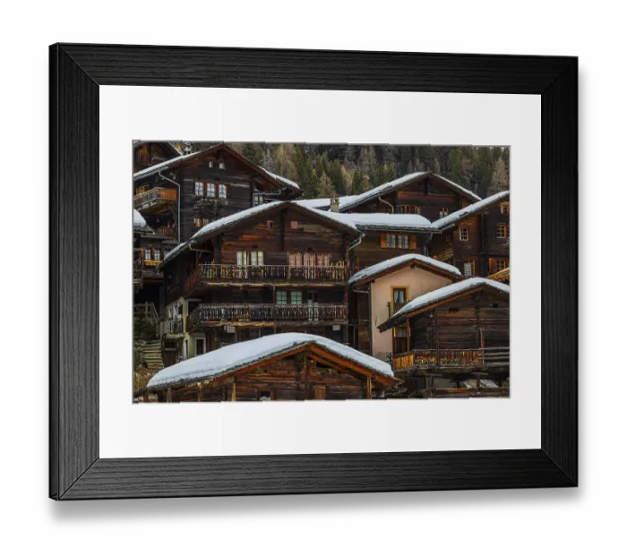 Framed Print : Old wooden houses with snow-covered roofs in the historic village centre