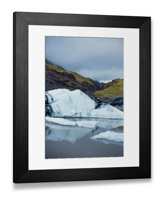 Framed Print : Ice surfaces against mountainous terrain and a cloudy sky
