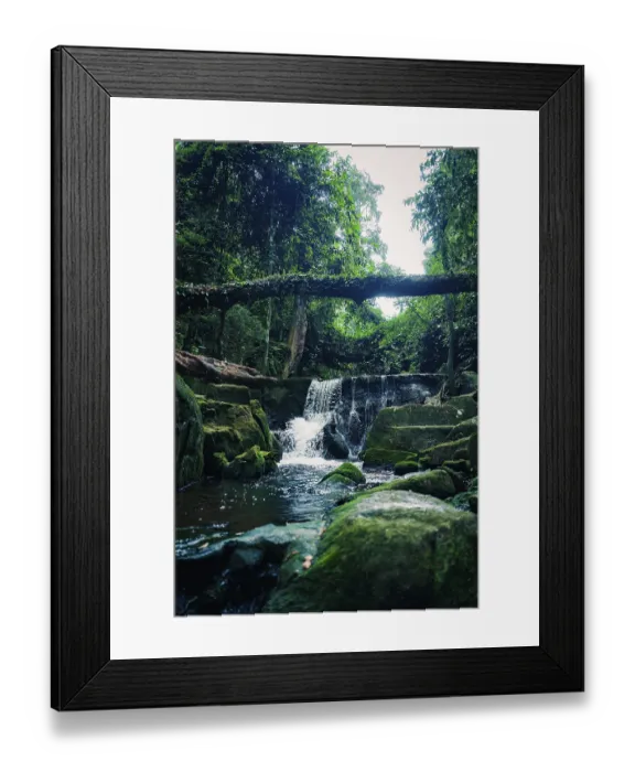 Framed Print : Waterfall in a verdant forest with rocks and lush greenery surrounding it Framed Print : Waterfall in a verdant forest with rocks and lush greenery surrounding it