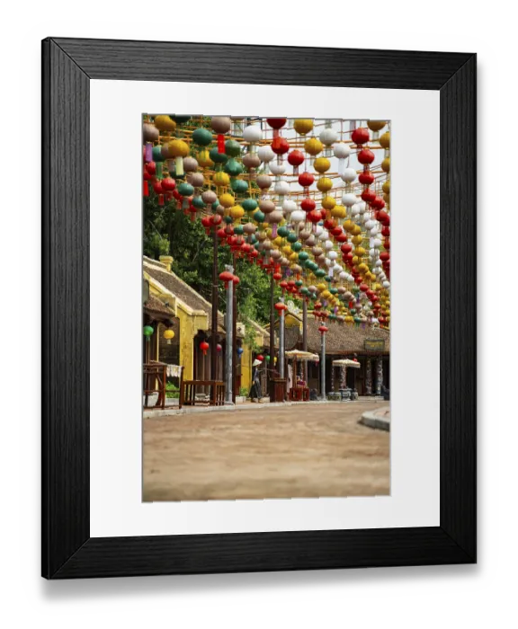 Framed Print : Yellow buildings line the street decorated with colorful hanging lanterns