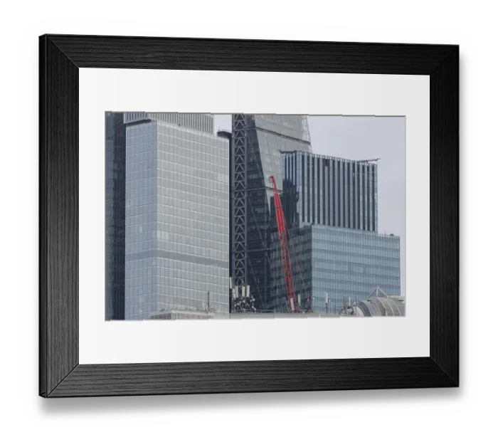 Framed Print : Mechanical red crane on a building in front of skyscrapers