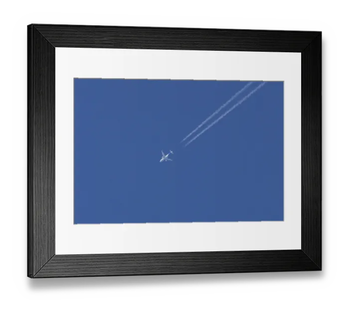 Framed Print : Jet passenger aircraft with a vapour trail or contrail flying in a blue sky