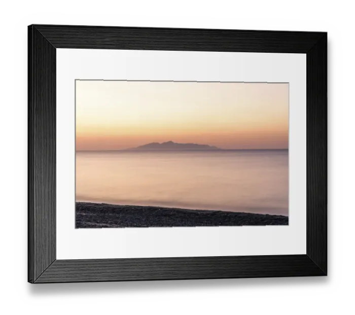 Framed Print : Dawn at sunrise, view from the lava beach near Kamari to the island of Anafi