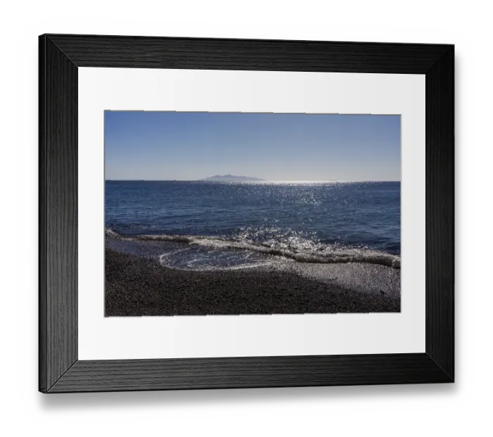 Framed Print : Glittering sea, surf waves on the lava beach of Kamari