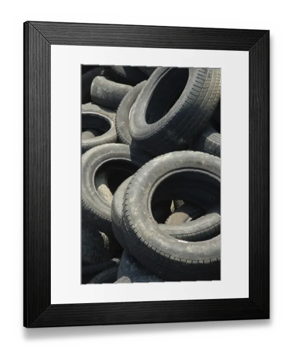 Framed Print : A large pile of old, worn tires stacked haphazardly Framed Print : A large pile of old, worn tires stacked haphazardly