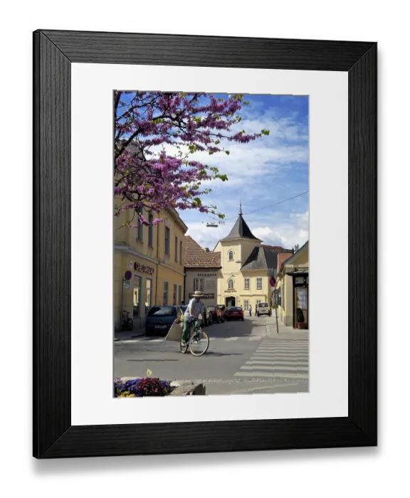 Framed Print : A cyclist and in the background the former townsmen hospital Baden Lower Austria