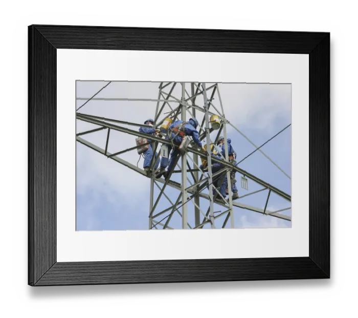 Framed Print : Industrial climber high up on an electricity pylon