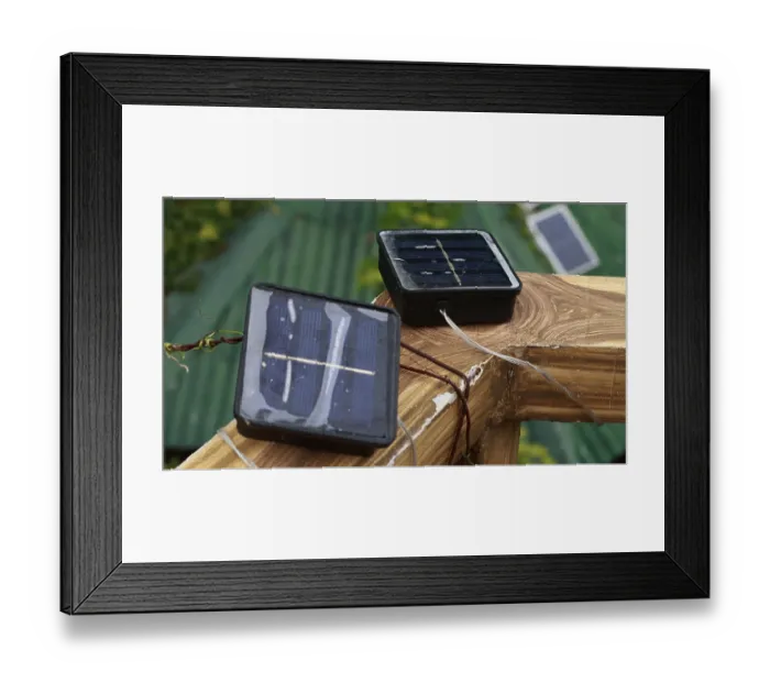 Framed Print : Small solar panels on a wooden surface with cables