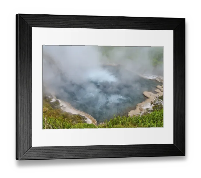 Framed Print : Steaming hot spring with blue water surrounded by green vegetation and rocks