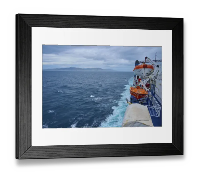 Framed Print : View from a ferry on stormy sea and lifeboats with coastal distance