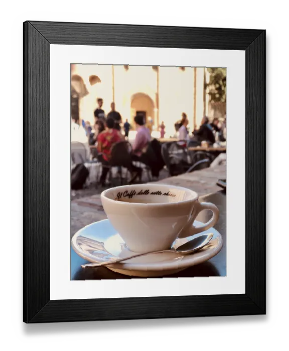 Framed Print : White coffee cup on a table in a busy street cafe