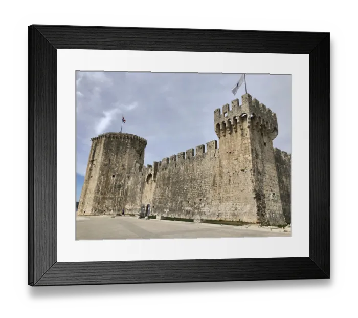 Framed Print : Imposing medieval stone castle with fortified walls and flags Framed Print : Imposing medieval stone castle with fortified walls and flags