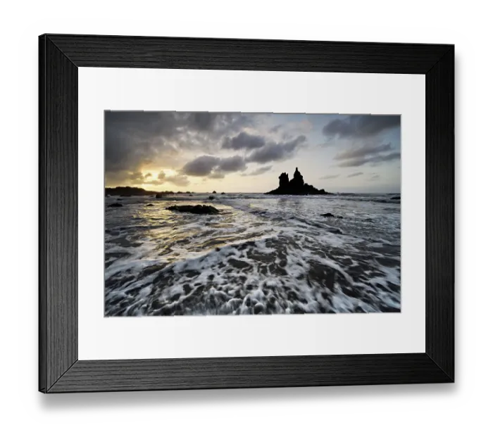Framed Print : Dramatic cloudy atmosphere with rock formation at rising tide at sunset on the beach of Playa de Benijo