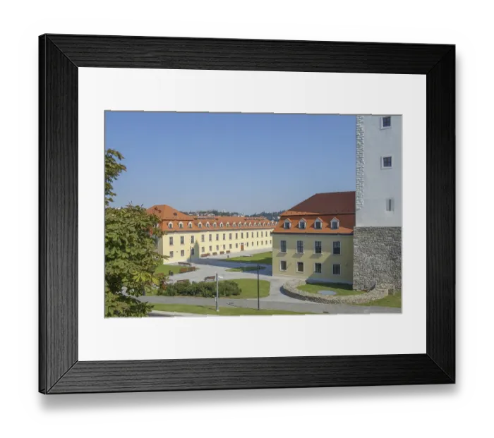 Framed Print : Yellow castle building with red roof in an open courtyard under a blue sky