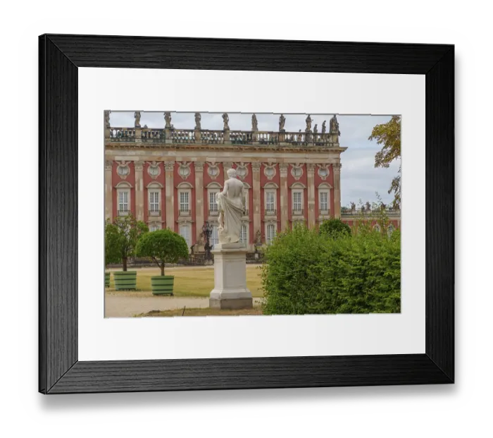 Framed Print : Statue in the foreground, behind a majestic building with a red facade and symmetrical windows