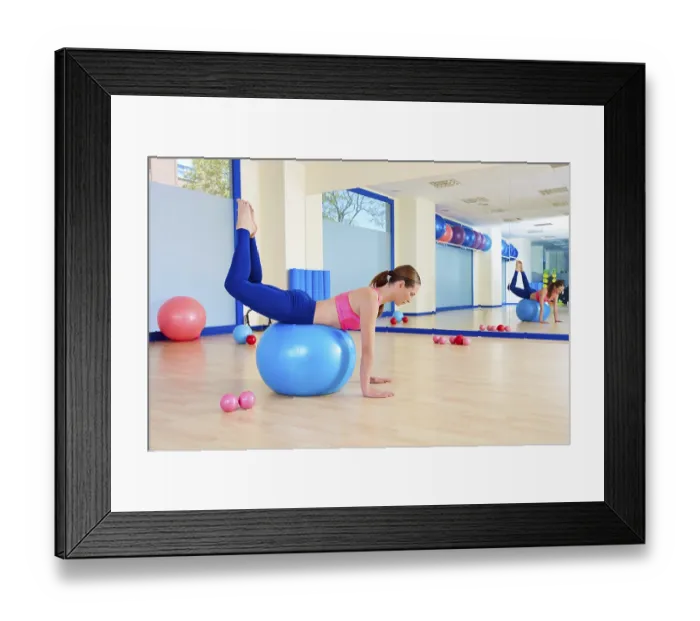 Framed Print : Pilates woman fitball rocking exercise workout at gym indoor