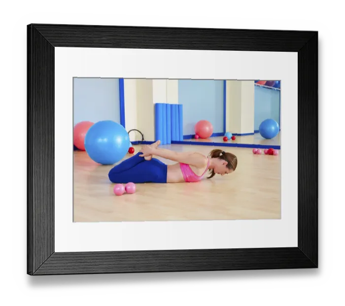 Framed Print : Pilates woman fitball rocking exercise workout at gym indoor